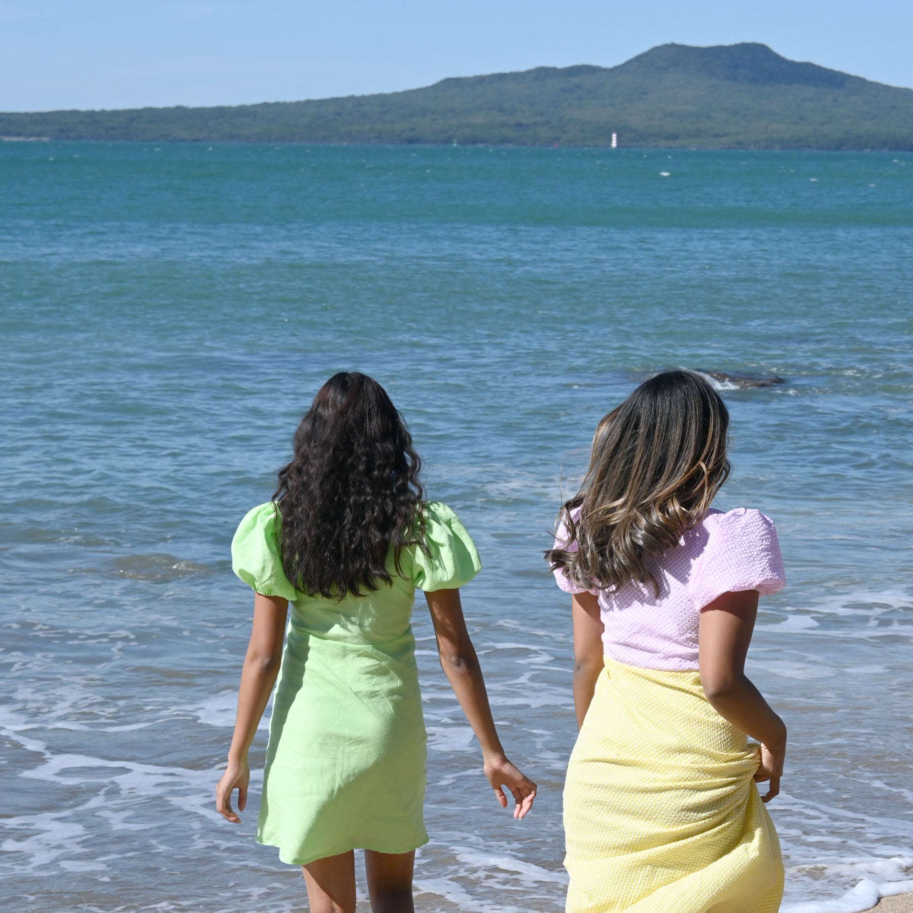 Stella Claire dresses at an Auckland beach, with Rangitoto in the background