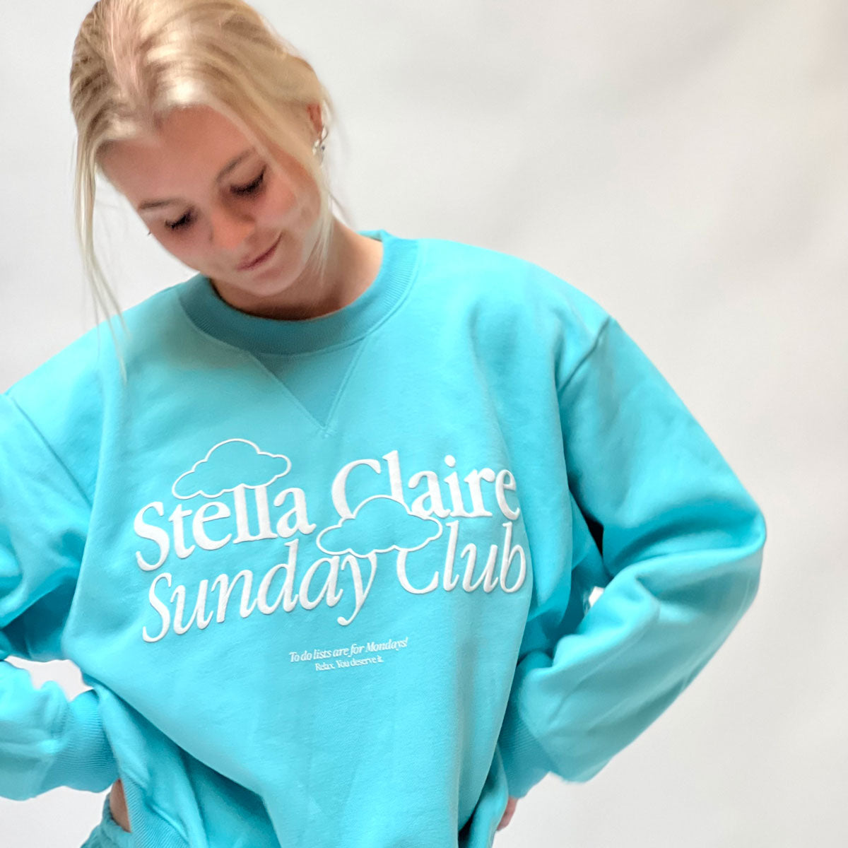 Sale items at Stella Claire, wearing a comfortable blue Sunday Club sweatshirt